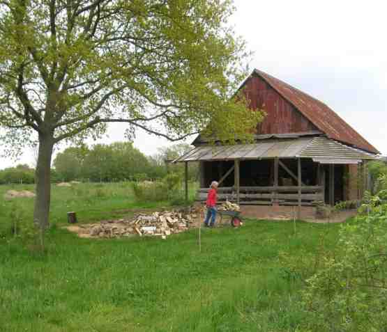 Andrea mit Schubkarre und Holz drauf beim Einlagern des Holzes.