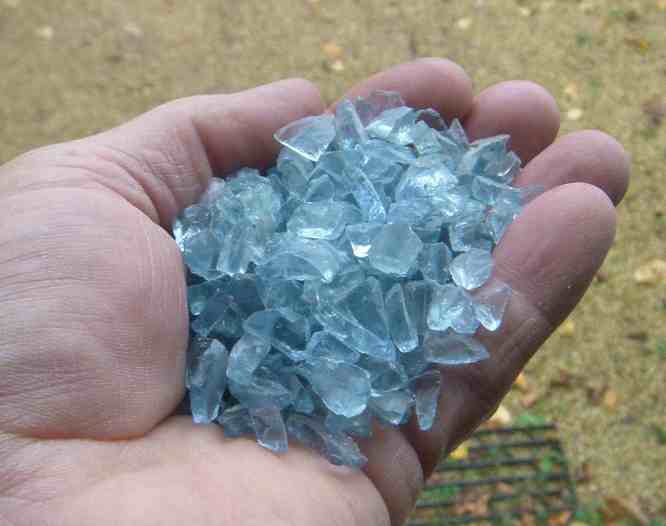 Hellblauer Glas-Splitt in meiner Hand.