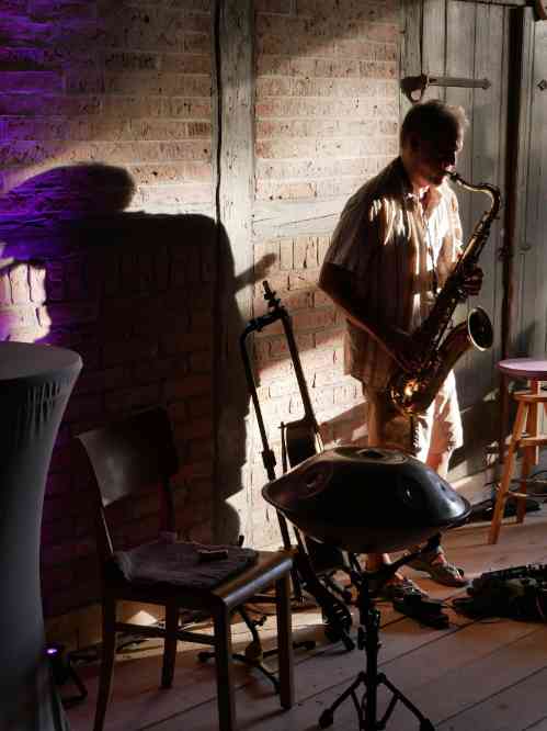 Helge spielt Saxophone stehend auf der Tenne.