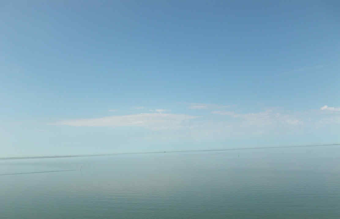 Nordsee und einer Hallig im Hintergrund.