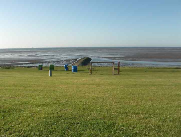 Nordsee bei Ebbe mit Deich und Strandkörben.