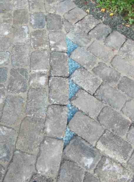 Kleine Dreiecke mit hellblauen Glassplitt verfüllt.
