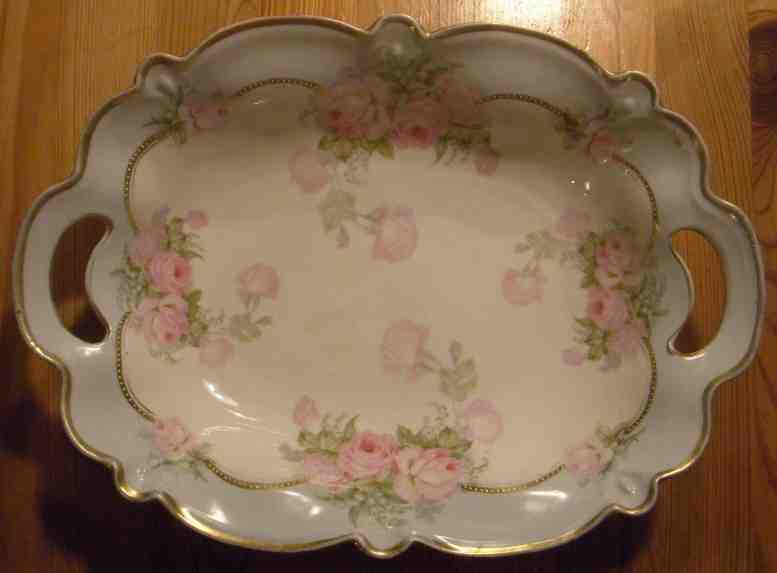 Gebäck- oder Obstschale mit gewellten, goldenen Rand, zur Mitte mit Rosenmotiven.