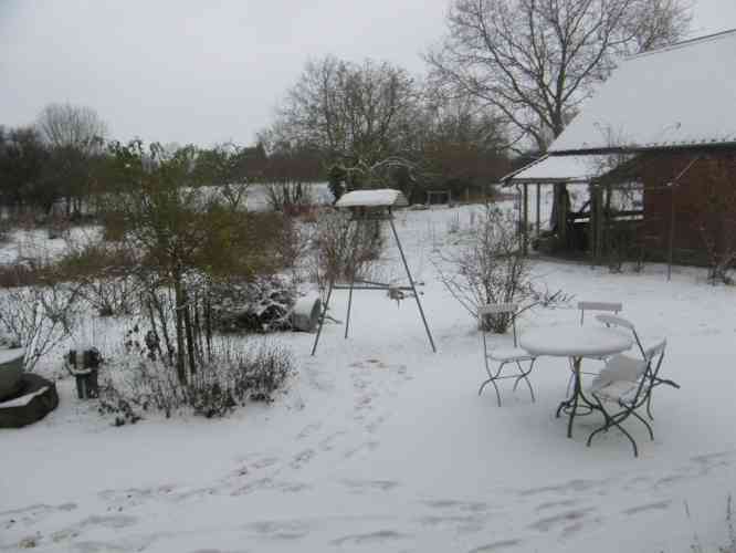 Schnee und Futterhaus für Vögel am Schuppen mit weißen Schneedach.